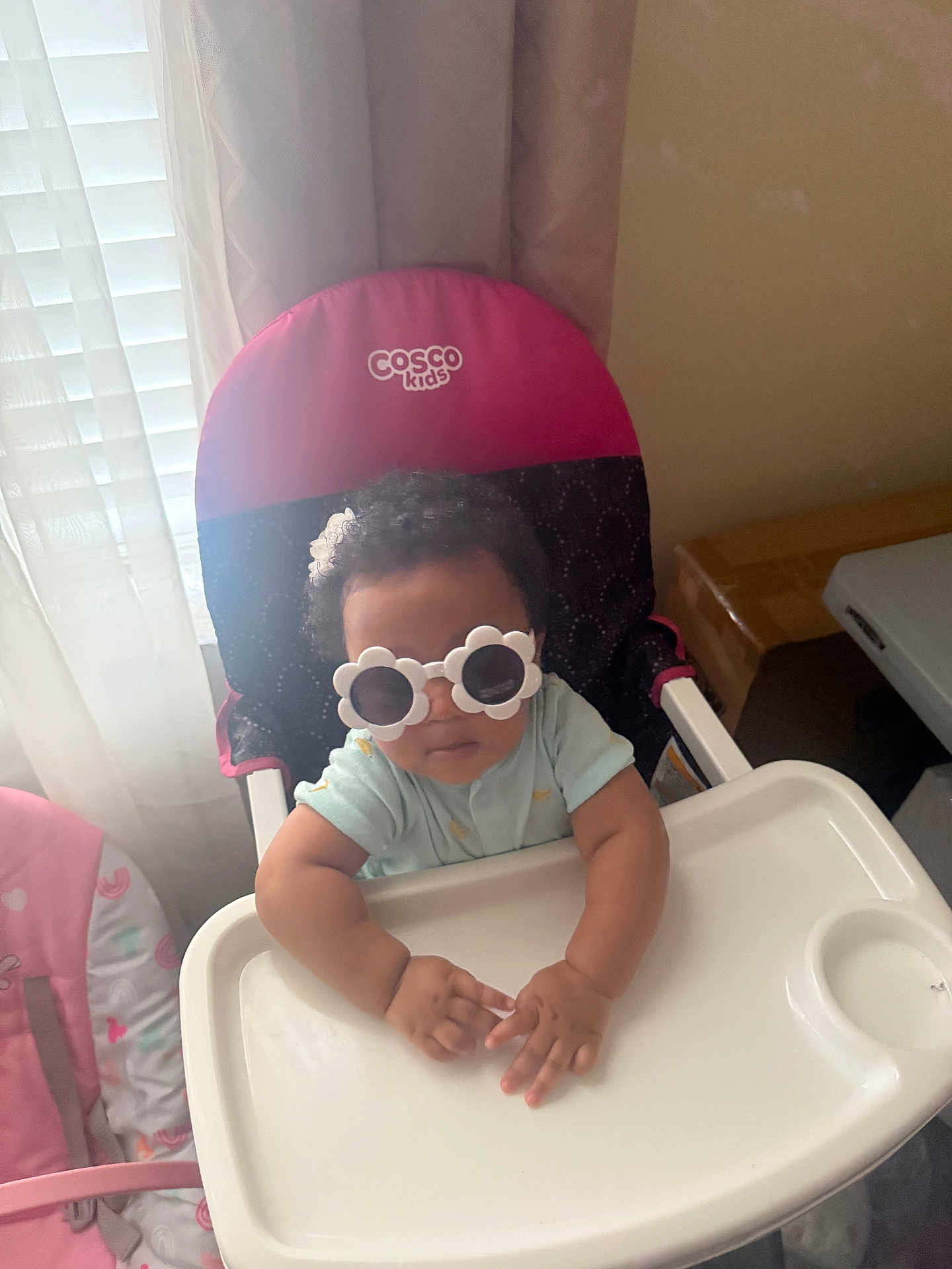 Taylr joined the competition — help win amazing prizes! baby, child, high_chair, sunglasses, flower_shaped, indoor, curtains, window, hand, face, person, clothing, pink, blue, cosco_kids, seat, table, cute, infant, home