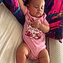 baby, sleeping, pink_onesie, pillow, colorful, tiger_design, bed, infant, peaceful, cute, child, arm_raised, relaxed, foot, skin, face, head, indoor, resting, soft