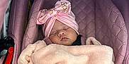 Kataleÿah participe au concours pour gagner de l'argent avec cette photo : baby, sleeping, blanket, car_seat, pink, headband, bow, face, infant, child, cozy, cute, soft, resting, newborn, wrapped, person, indoors, closeup, peaceful