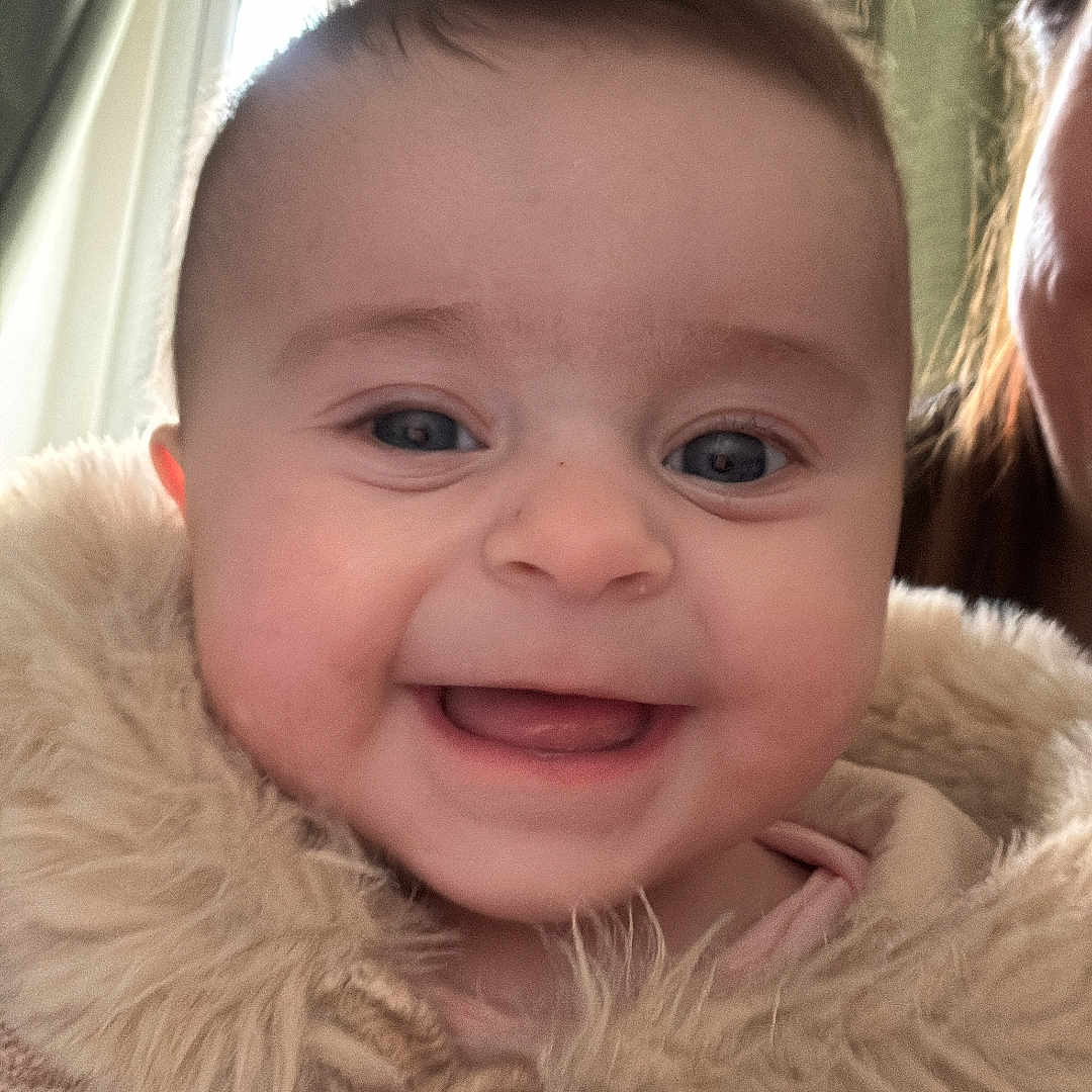 Isabella is registered to the contest to win money with this photo: baby, bodypart, child, clothing, coat, face, female, girl, happy, head, jacket, knitwear, laughing, mouth, person, photography, portrait, smile, sweater, teeth