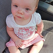 Aaliyah is registered to the contest to win money with this photo: arm, baby, car_seat, casual, child, clothing, curious_eyes, cute, face, indoor, legs, person, pink_skirt, portrait, seat, sitting, sunlight, toddler, white_top, young_child