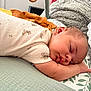 baby, sleeping, infant, pillow, blanket, arm, face, cozy, rest, soft, pattern, toy, wooden_ring, closeup, peaceful, child, indoors, cute, nap, toddler