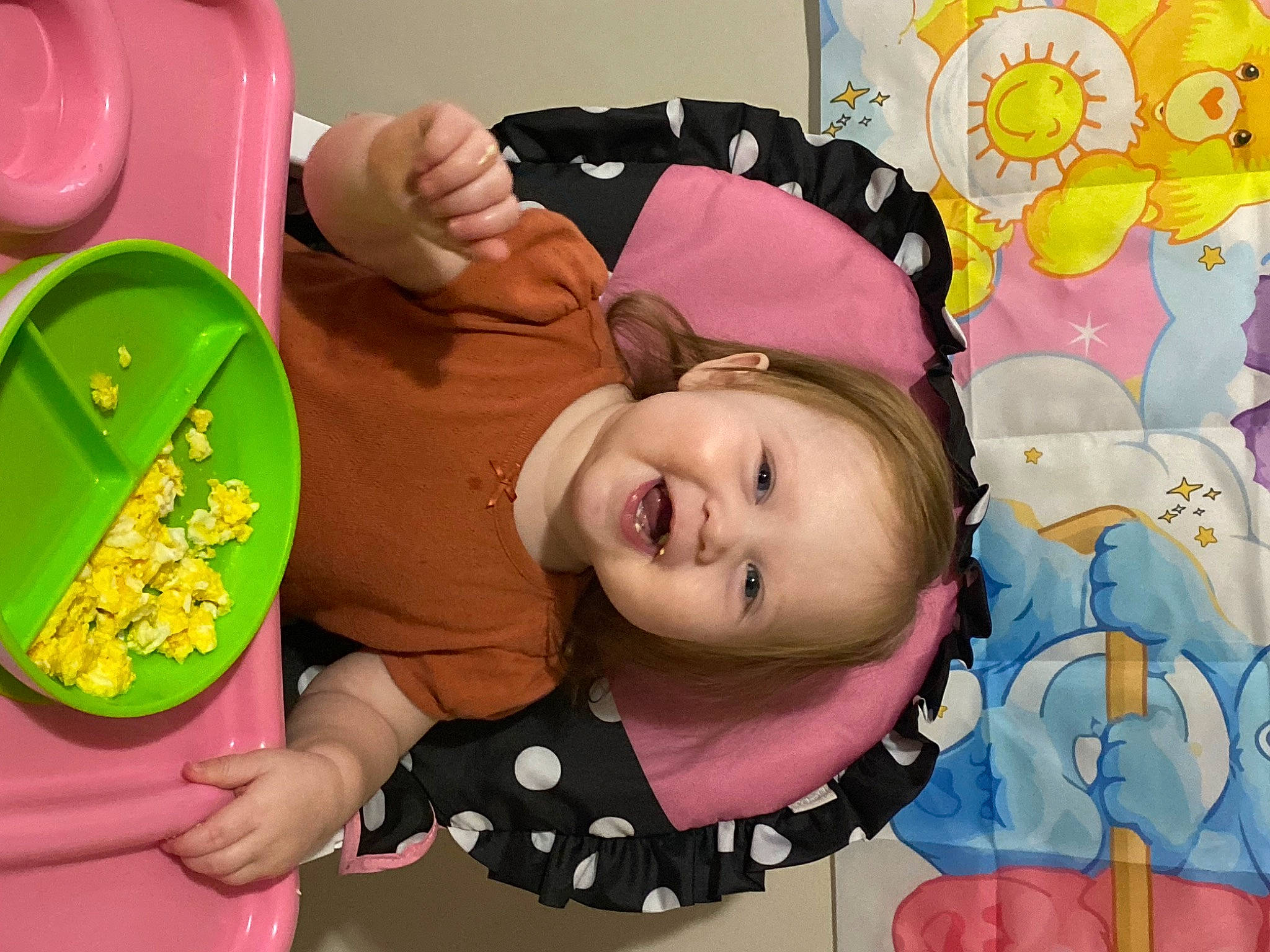 Angel is registered to the contest to win money with this photo: baby, baby_toddler_clothing, cheek, child, comfort_food, dishware, food, fun, happy, pattern, person, pink, plate, play, room, smile, sweetness, tableware, textile, toddler