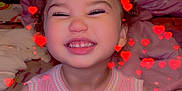 Saylor is registered to the contest to win money with this photo: toddler, child, smiling, pink_dress, curly_hair, indoor, bedroom, heart_effects, happy, cute, sitting, window_blinds, blanket, soft_toys, face, portrait, young_child, playful, decor, cozy