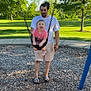Saylor is registered to the contest to win money with this photo: child, adult, swing, playground, park, tree, grass, daylight, happy, smiling, casual_clothing, sandals, shorts, toddler, outdoor, nature, recreation, fun, family, person