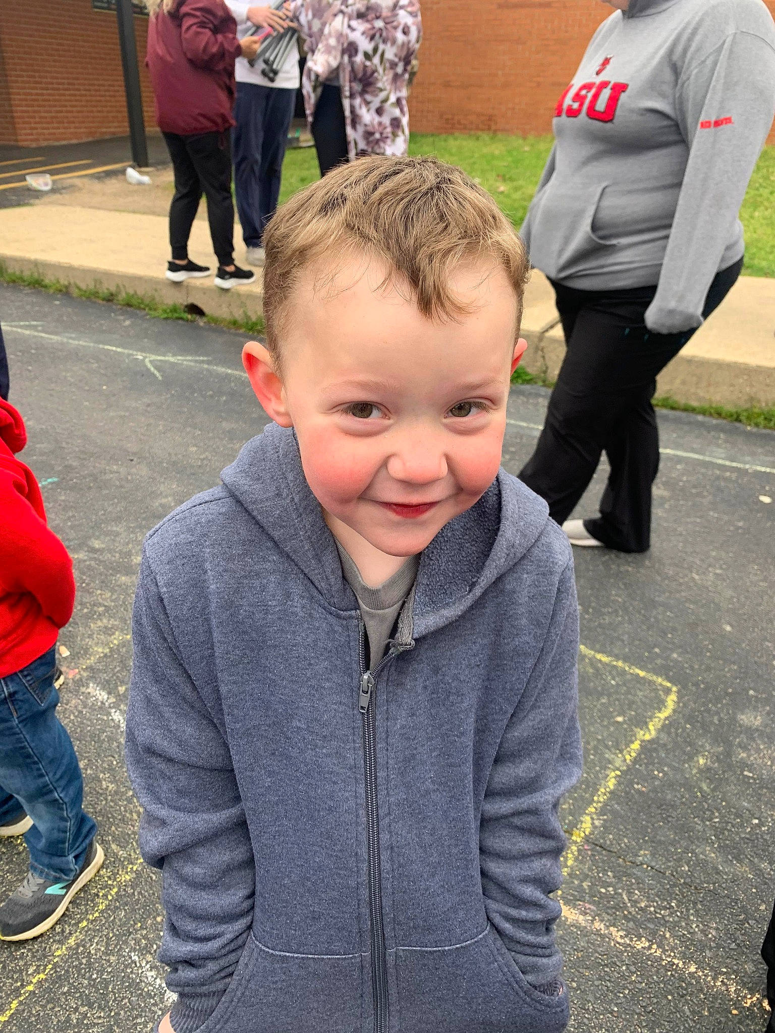 Houston is registered to the contest to win money with this photo: asphalt, child, crowd, event, footwear, fun, gesture, happy, joy, leisure, pedestrian, person, public_event, recreation, shoe, sleeve, smile, toddler, tradition, trousers