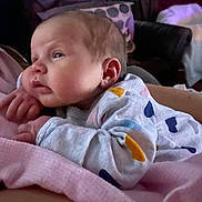 Harlynn is registered to the contest to win money with this photo: baby, infant, blanket, clothing, heart_pattern, pink_blanket, sleepwear, face, hand, cute, child, newborn, indoor, soft_texture, resting, portrait, person, warm, cozy, sleepy