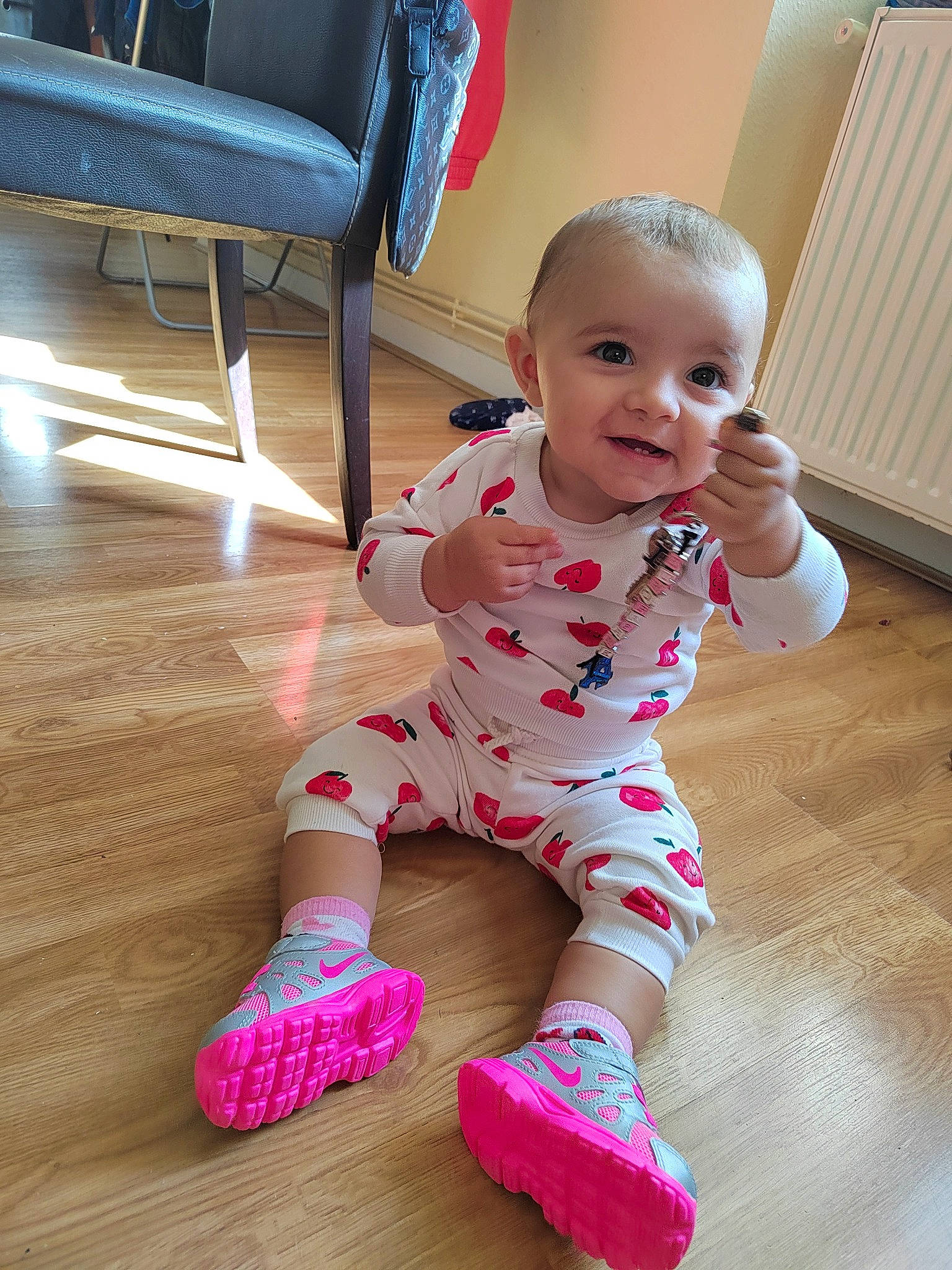 Naïla a rejoint le concours — aidez-le/la à gagner de superbes lots ! baby, baby_toddler_clothing, cheek, facial_expression, floor, flooring, fun, happy, hardwood, human_body, human_leg, knee, person, pink, skin, sleeve, smile, sock, thigh, toddler