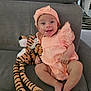 Alma participe au concours pour gagner de l'argent avec cette photo : baby, infant, smiling, happy, plush_toy, tiger_toy, peach_outfit, headband, couch, gray_furniture, cute, child, sitting, indoors, soft_toy, playful, portrait, skin, legs, feet