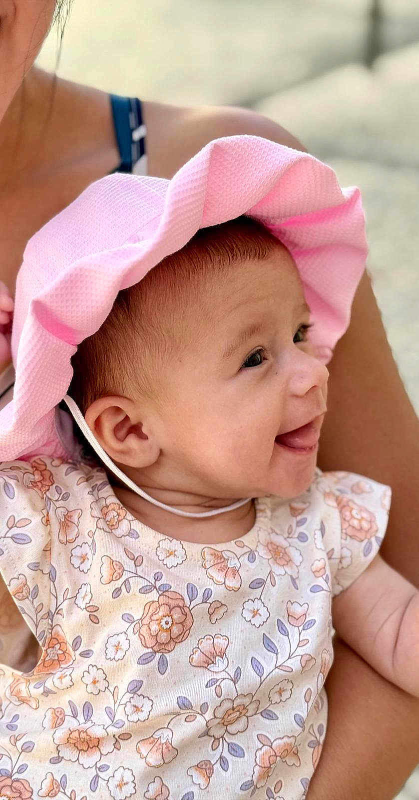 Alma a rejoint le concours — aidez-le/la à gagner de superbes lots ! baby, child, smiling, hat, pink_hat, floral_dress, infant, portrait, happy, cute, face, person, skin, arm, head, clothing, summer, outdoor, parent, holding
