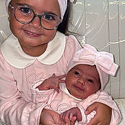 Hayden a rejoint le concours — aidez-le/la à gagner de superbes lots ! child, baby, sibling, pink_clothing, matching_outfits, headband, bow, glasses, smile, holding, couch, indoor, portrait, cute, family, happy, toddler, newborn, hands, cozy