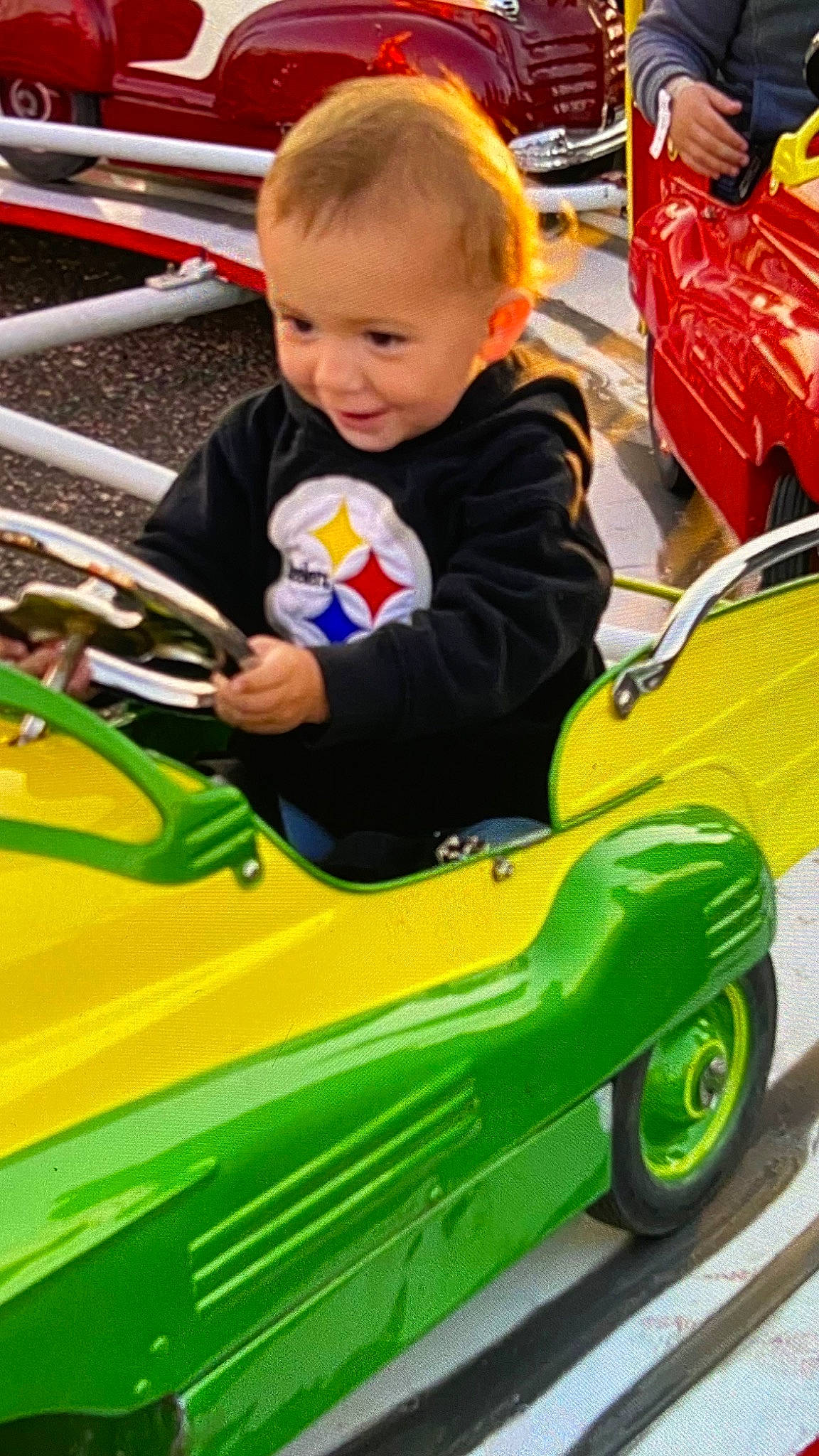 Korbyn joined the competition — help win amazing prizes! automotive_design, automotive_exterior, automotive_tire, baby, car, child, fun, green, hood, leisure, motor_vehicle, person, photograph, riding_toy, smile, t_shirt, tire, toddler, vehicle, wheel