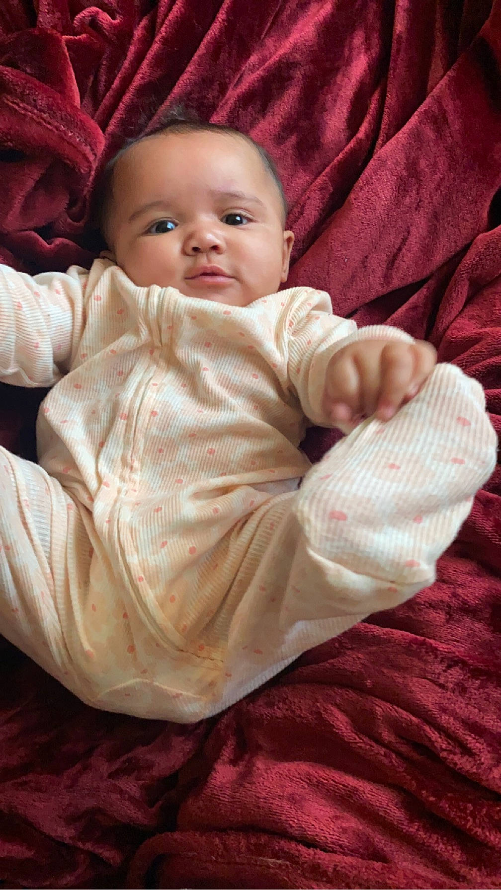 Amira is registered to the contest to win money with this photo: baby, baby_toddler_clothing, carmine, cheek, child, chin, comfort, face, flooring, fur, happy, head, linens, lip, person, pink, sitting, skin, sleeve, smile