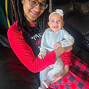 Syilynne is registered to the contest to win money with this photo: woman, baby, glasses, dreadlocks, smile, happy, holding, pajamas, headband, flower, couch, leather, red, black, checkered, holiday, indoor, portrait, family, cozy