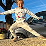 Lya participe au concours pour gagner de l'argent avec cette photo : child, girl, pose, smile, outdoor, tree, car, sunlight, sweatshirt, pants, shoes, stone, playful, casual, daytime, nature, happy, person, blue_sky, leisure