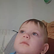 Liam is registered to the contest to win money with this photo: child, boy, blue_shirt, face, portrait, indoor, young, curious, looking_up, head, short_hair, phone_screenshot, app_icons, wall, furniture, casual_clothing, earring, necklace, home, soft_lighting