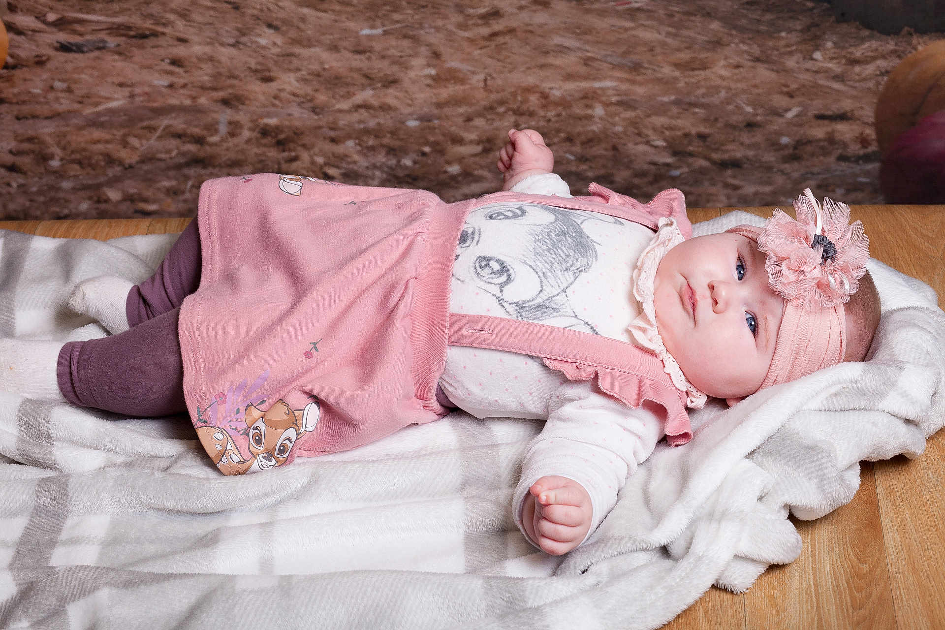 Eliza a rejoint le concours — aidez-le/la à gagner de superbes lots ! baby, infant, pink_dress, headband, flower, blanket, wooden_floor, blue_eyes, cute, portrait, lying_down, soft_texture, warm, child, toddler, indoors, clothing, person, baby_girl, resting