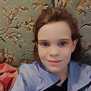 Rose participe au concours pour gagner de l'argent avec cette photo : child, face, smile, eyes, hair, selfie, jacket, zipper, couch, upholstery, floral_pattern, patterned_background, indoor, portrait, young_person, headshot, skin, casual_clothing, soft_lighting, close_up