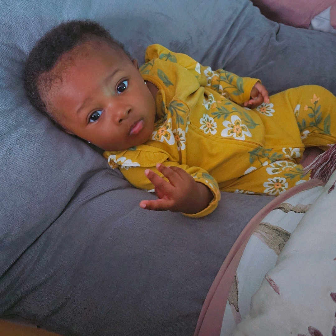 Safiya joined the competition — help win amazing prizes! baby, bed, blanket, bodypart, clothing, couch, crib, cushion, dress, face, finger, formalwear, furniture, hand, head, homedecor, infantbed, person, photography, portrait