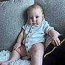 baby, child, infant, sitting, couch, sofa, portrait, indoors, home, blue_eyes, white_shirt, buttoned_outfit, bare_feet, blanket, pillow, cushion, furniture, centered, calm, photograph