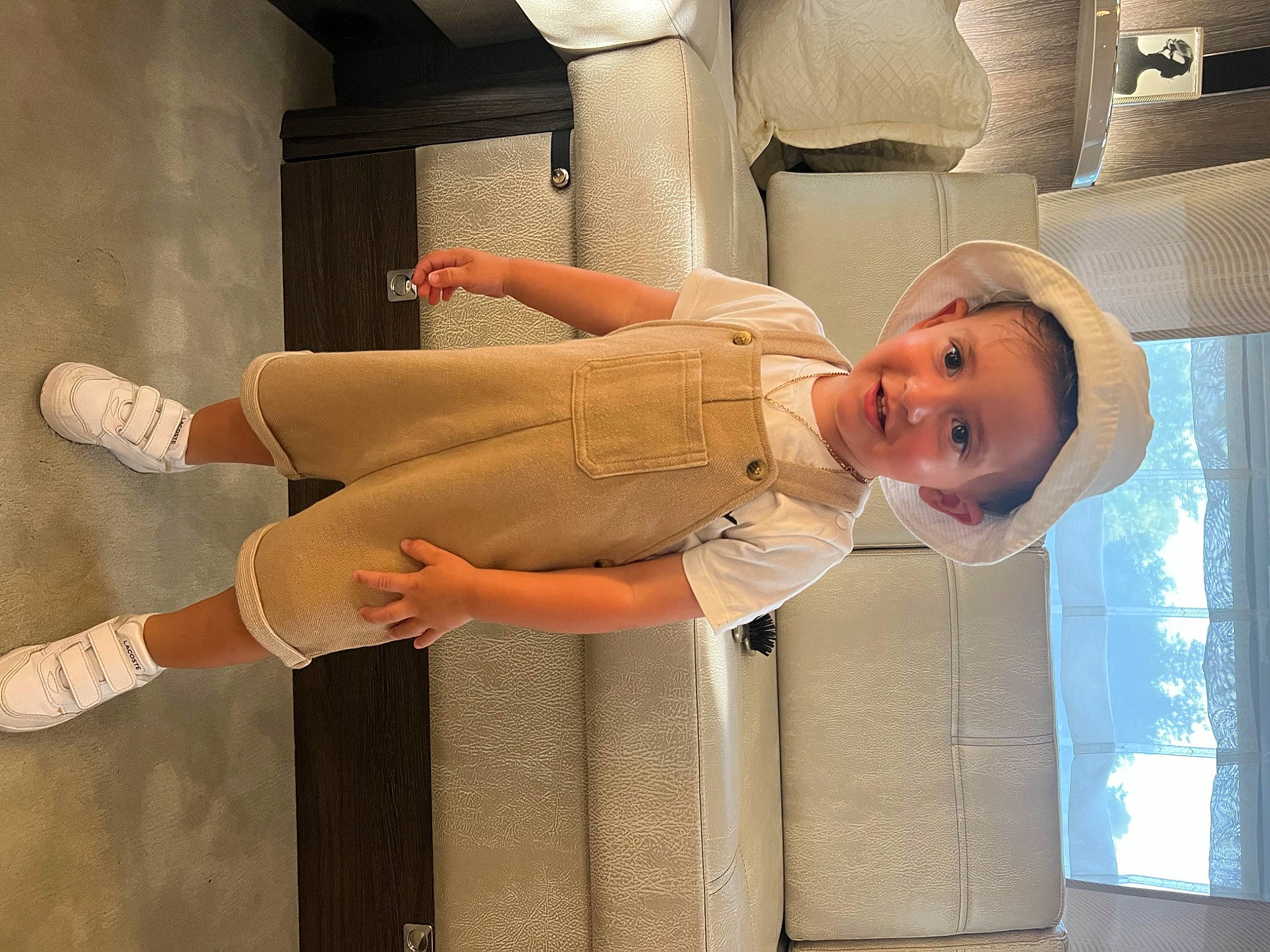 Milann participe au concours pour gagner de l'argent avec cette photo : baby, baby_products, baby_safety, baby_toddler_clothing, child, comfort, elbow, foot, hat, human_leg, joy, knee, peach, person, room, sandal, sitting, smile, sock, thigh