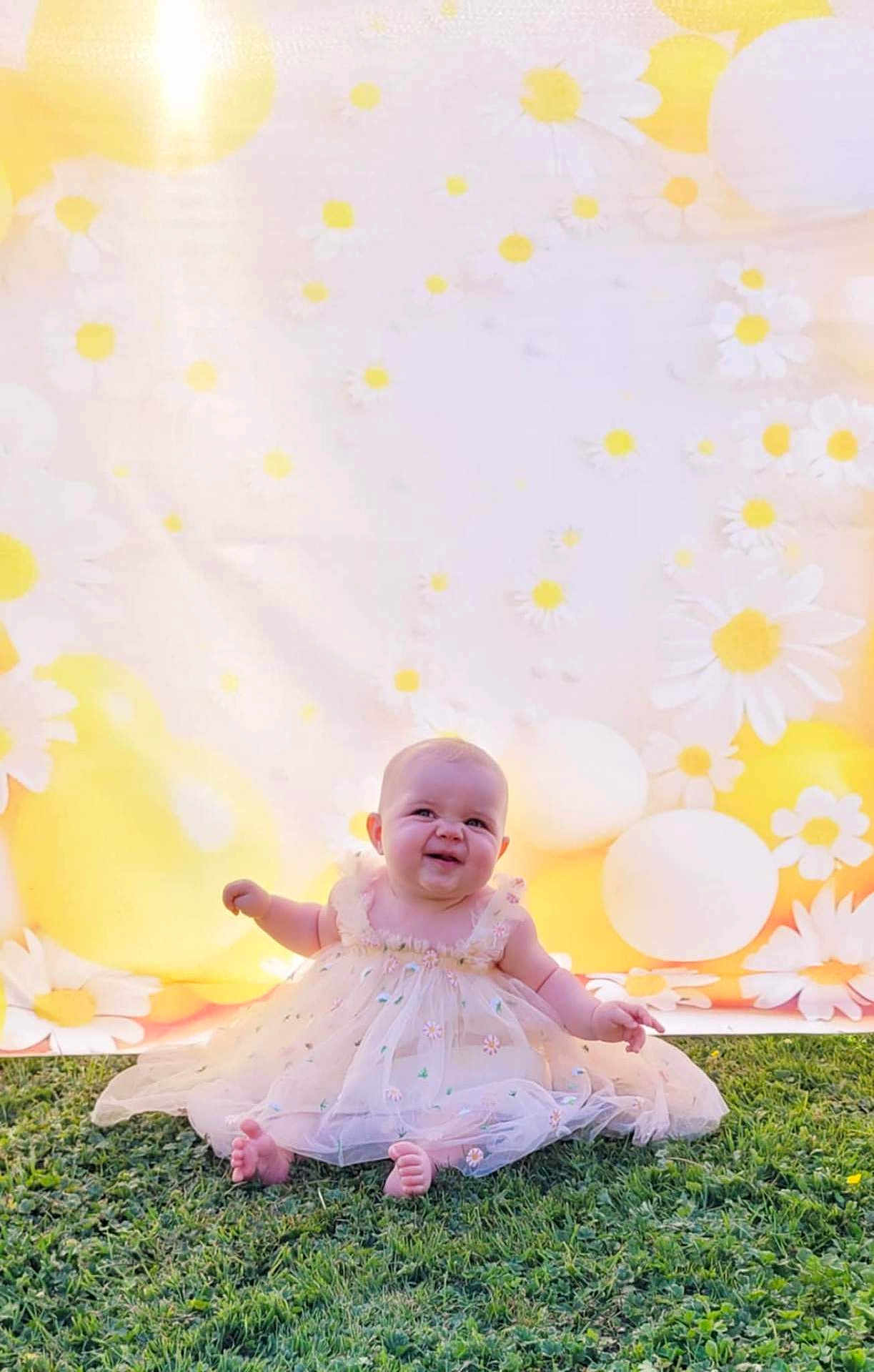Ambre participe au concours pour gagner de l'argent avec cette photo : baby, child, grass, dress, floral, smile, outdoor, flower_pattern, balloon, background, greenery, sitting, cute, happy, sunlight, nature, portrait, infant, celebration, yellow