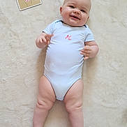 Ambre participe au concours pour gagner de l'argent avec cette photo : baby, infant, smiling, onesie, milestone_card, blanket, lying_down, happy, cute, child, soft_texture, skin, chubby_legs, indoors, portrait, young_child, celebration, milestone, baby_clothes, resting