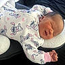 Nalani is registered to the contest to win money with this photo: newborn, baby, sleeping, infant, onesie, clothing, cartoon_print, fabric, cushion, bed, comfort, rest, peaceful, soft, cute, child, person, indoors, portrait, closeup