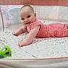 Melissa is registered to the contest to win money with this photo: baby, infant, playpen, mesh, pink_outfit, smiling, tummy_time, toy, green_toy, bedding, indoor, child, cute, happy, person, floor, blanket, home, reaching, young_child