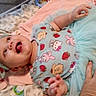 baby, infant, smiling, child, clothing, headband, hand, blanket, tutu, pattern, cute, indoor, person, soft_toys, happy, lying_down, colorful, playful, fabric, portrait