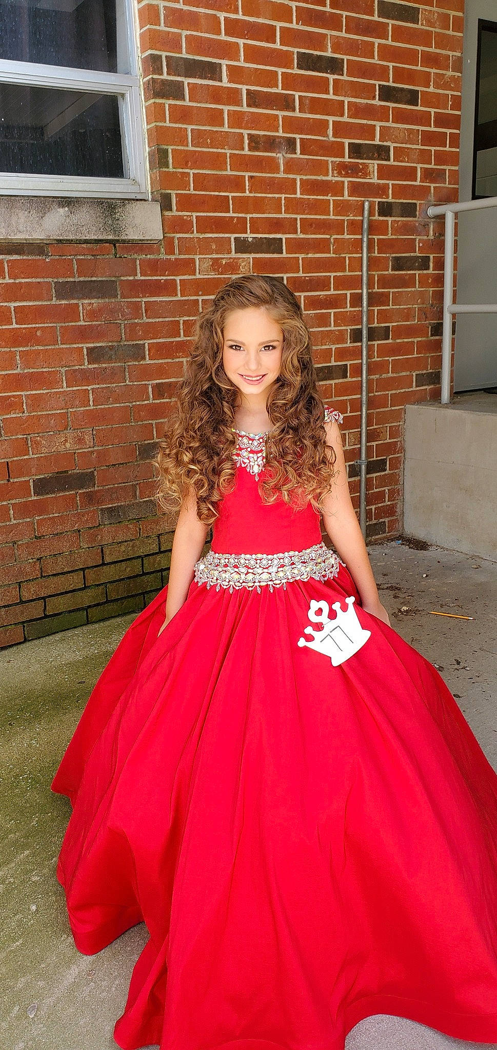 Daniella is registered to the contest to win money with this photo: brick, brickwork, bridal_party_dress, cool, day_dress, dress, embellishment, face, gown, hair, happy, head, iris, joy, neck, one_piece_garment, person, pink, shoulder, sleeve