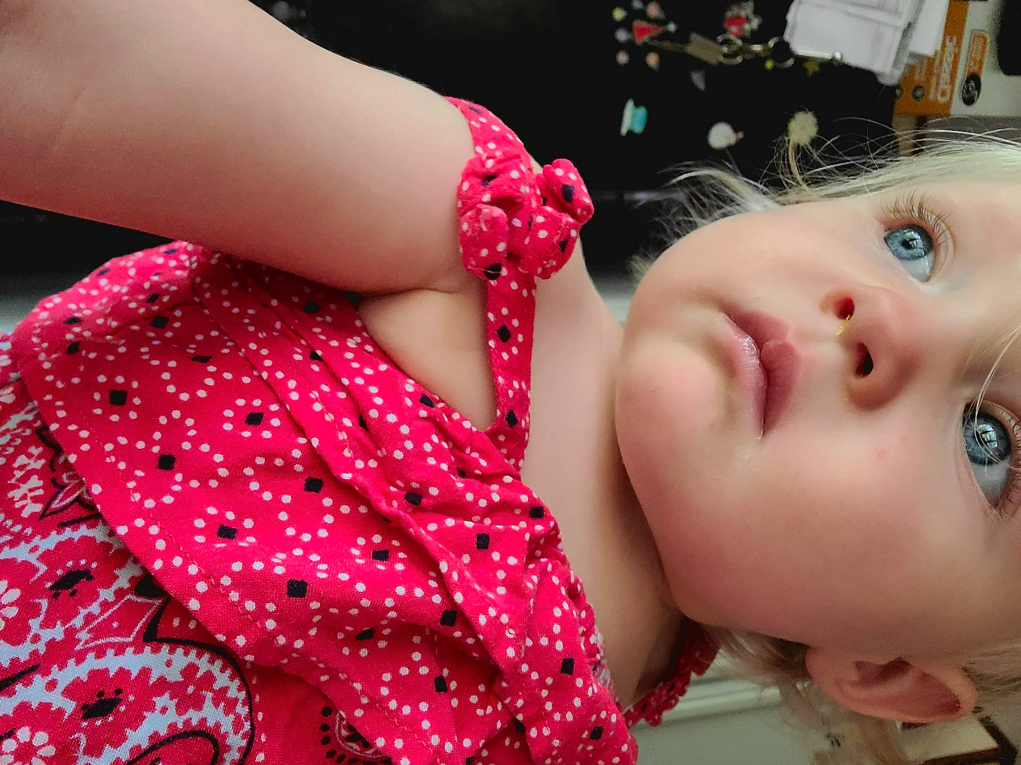 Theia is registered to the contest to win money with this photo: arm, baby, cheek, child, design, ear, fashion_accessory, finger, flesh, hand, headwear, lip, mouth, nail, neck, pattern, person, pink, polka_dot, skin