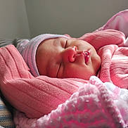 Zoey is registered to the contest to win money with this photo: newborn, baby, sleeping, pink_clothing, hat, blanket, soft_light, closeup, infant, peaceful, cute, warm, cozy, portrait, resting, indoors, face, child, toddler, wrapped