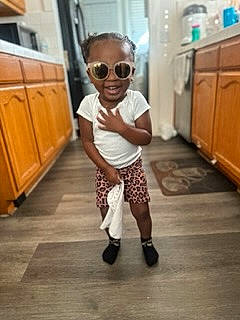 Rose is registered to the contest to win money with this photo: baby_toddler_clothing, cabinetry, drawer, eyewear, floor, flooring, glasses, goggles, joint, leg, mammal, person, shoulder, sleeve, standing, sunglasses, t_shirt, toddler, vision_care, waist