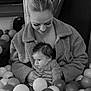 baby, woman, ball_pit, play_area, fuzzy_jacket, indoor, child, netting, balls, holding, cute, portrait, monochrome, parent, infant, casual_clothing, happy, togetherness, soft_texture, family