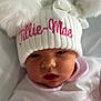 Tillie-Mae joined the competition — help win amazing prizes! baby, infant, hat, pom_poms, white_hat, pink_text, clothing, blanket, bed, cute, face, hand, sleepwear, newborn, portrait, cozy, soft_texture, indoor, child, person