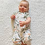 baby, child, cozy, cute, face, feet, fluffy_rug, hands, happy, indoors, infant, lying_down, patterned_clothing, portrait, romper, skin, smiling, soft_texture, white_rug, wood_floor