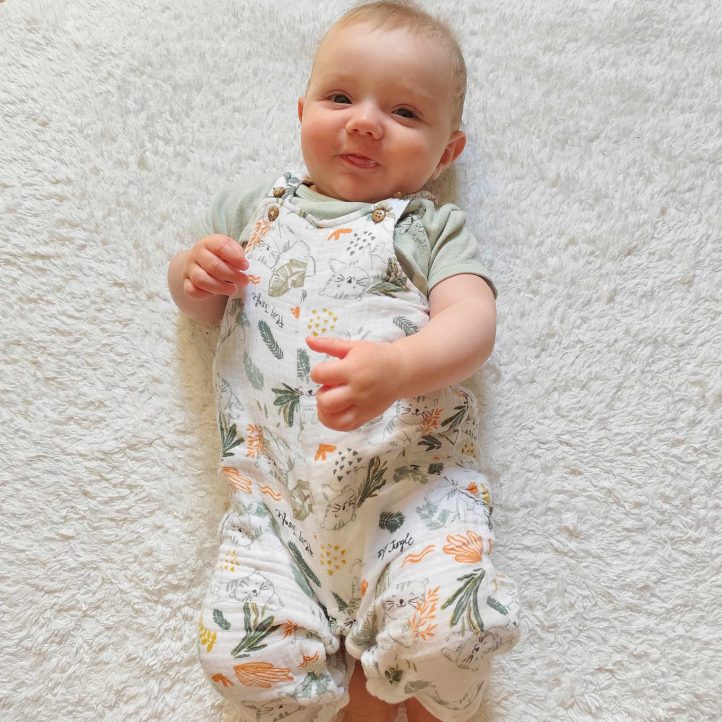 Emile a rejoint le concours — aidez-le/la à gagner de superbes lots ! baby, child, cozy, cute, face, feet, fluffy_rug, hands, happy, indoors, infant, lying_down, patterned_clothing, portrait, romper, skin, smiling, soft_texture, white_rug, wood_floor