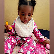 Journie is registered to the contest to win money with this photo: toddler, child, baby, pajamas, hello_kitty, bib, snack, toy_phone, pink, sock, blanket, indoor, sitting, curious, play, toy, colorful, face, hair, expression