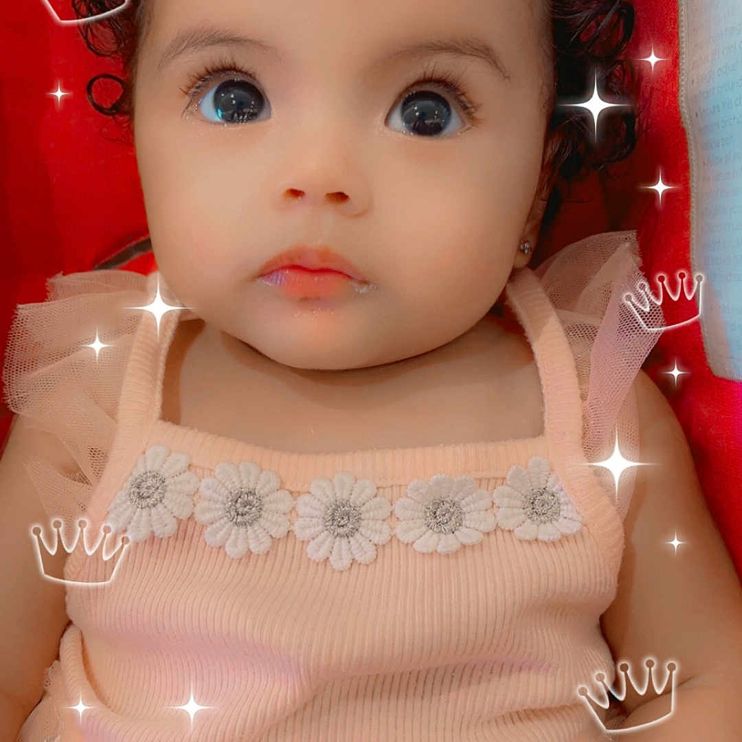 Tzarella is registered to the contest to win money with this photo: adorable, baby, child, closeup, crown, curly_hair, cute, digital_overlay, dress, flower, infant, looking_up, person, pink, portrait, red_background, smileless, soft, sparkle, tulle