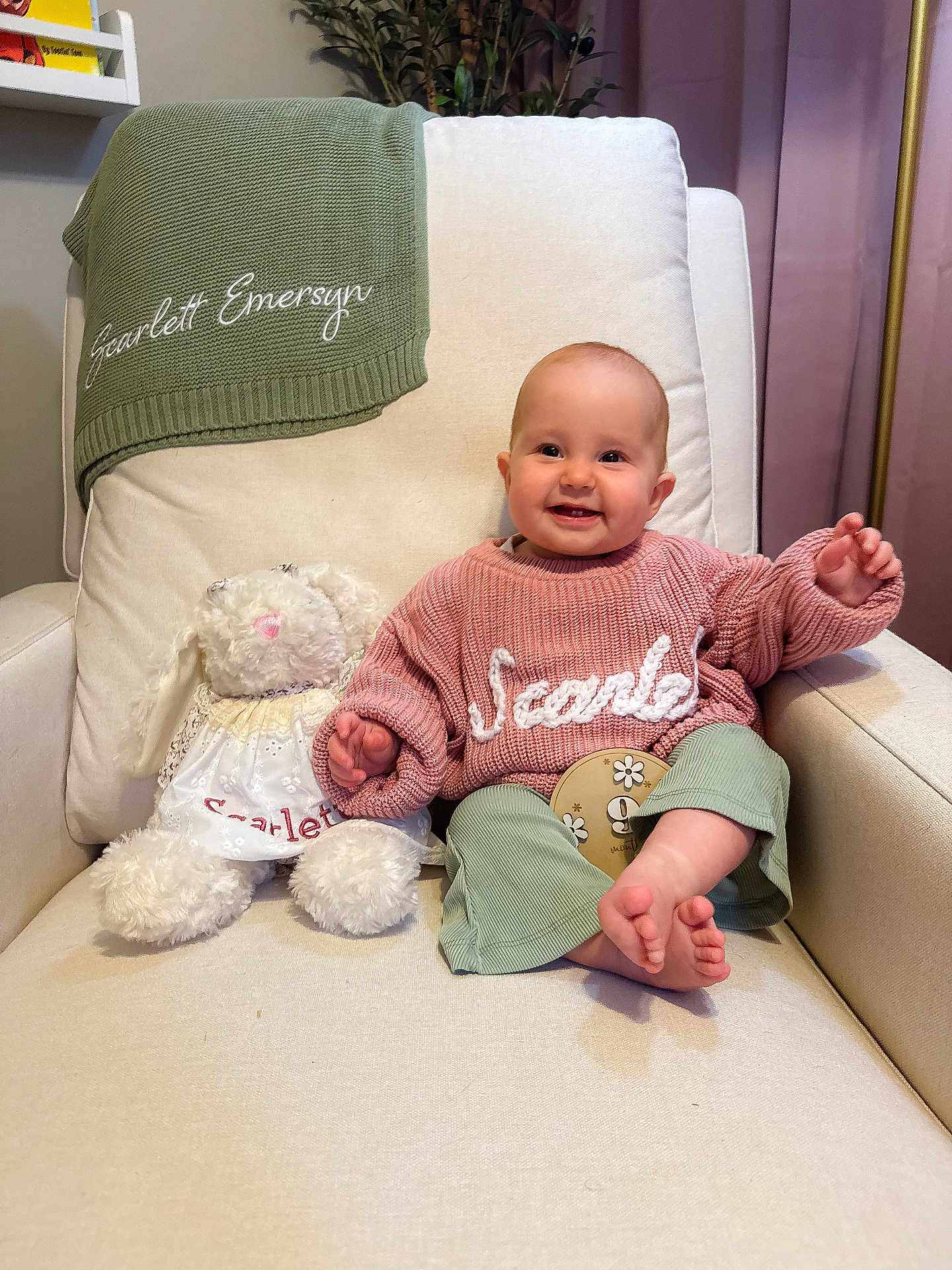 Scarlett is registered to the contest to win money with this photo: baby, smiling, child, stuffed_animal, armchair, blanket, knitwear, toy, indoor, plant, curtains, person, portrait, cute, happy, furniture, cozy, clothing, footwear, home_decor