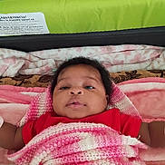 Jamie Lynn is registered to the contest to win money with this photo: baby, infant, blanket, pink, red_clothing, bed, headboard, knit, face, expression, lying_down, indoors, soft_texture, curly_hair, skin, portrait, child, warm, cozy, sleeping_area