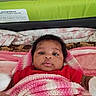 Jamie Lynn is registered to the contest to win money with this photo: baby, infant, blanket, knitted_blanket, red_clothing, bed, cushion, soft_toys, face, portrait, child, indoors, lying_down, comfort, cute, newborn, cozy, warm, expression, resting