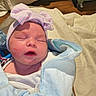 Ava is registered to the contest to win money with this photo: newborn, baby, infant, sleeping, face, portrait, hat, bow, striped_hat, blanket, swaddled, bundled, cozy, bed, bedroom, indoors, soft_lighting, pink, blue, peaceful