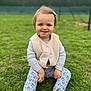 toddler, child, grass, outdoor, smiling, vest, striped_shirt, floral_leggings, shoes, hair_bow, sitting, young_child, nature, casual_clothing, portrait, happy, daylight, cute, playful, greenery