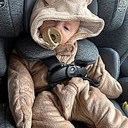 Ellie is registered to the contest to win money with this photo: baby, child, car_seat, onesie, pacifier, plush, hood, straps, seatbelt, cute, infant, sleepy, soft, clothing, comfort, car, safety, face, head, babywearing