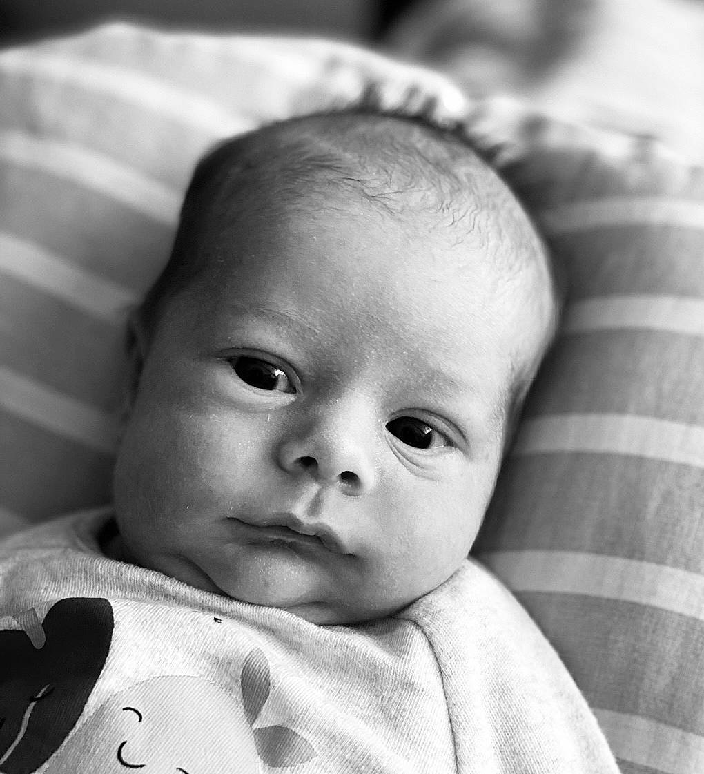 Louis is registered to the contest to win money with this photo: baby, black, cheek, chin, comfort, eye, eyebrow, face, facial_expression, forehead, head, lip, mouth, nose, person, photograph, product, skin, sleeve, smile