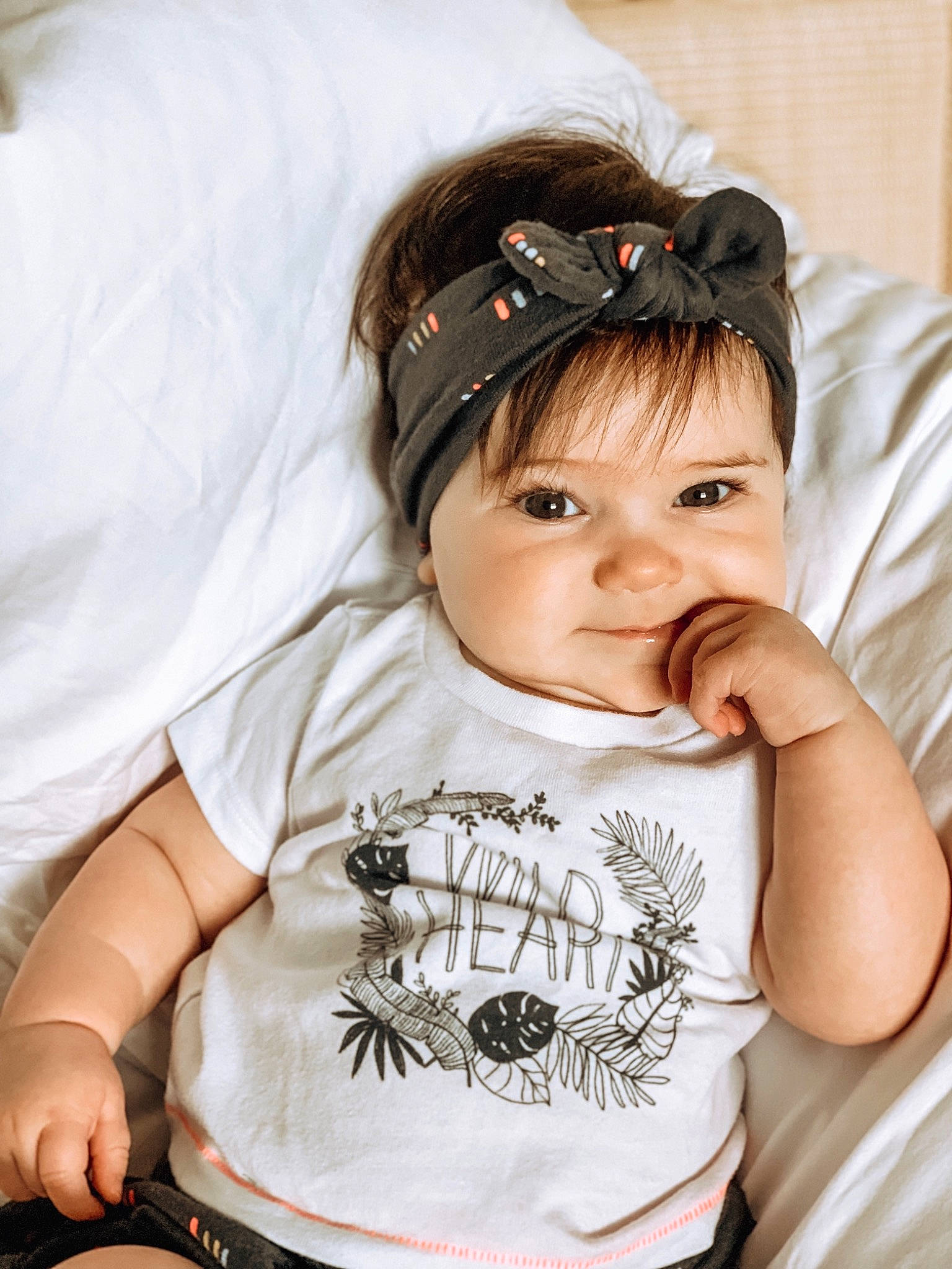 Siena is registered to the contest to win money with this photo: arm, baby, cheek, child, cool, ear, fashion_accessory, hair_accessory, hand, headband, headgear, headpiece, joint, joy, neck, person, photography, product, skin, t_shirt
