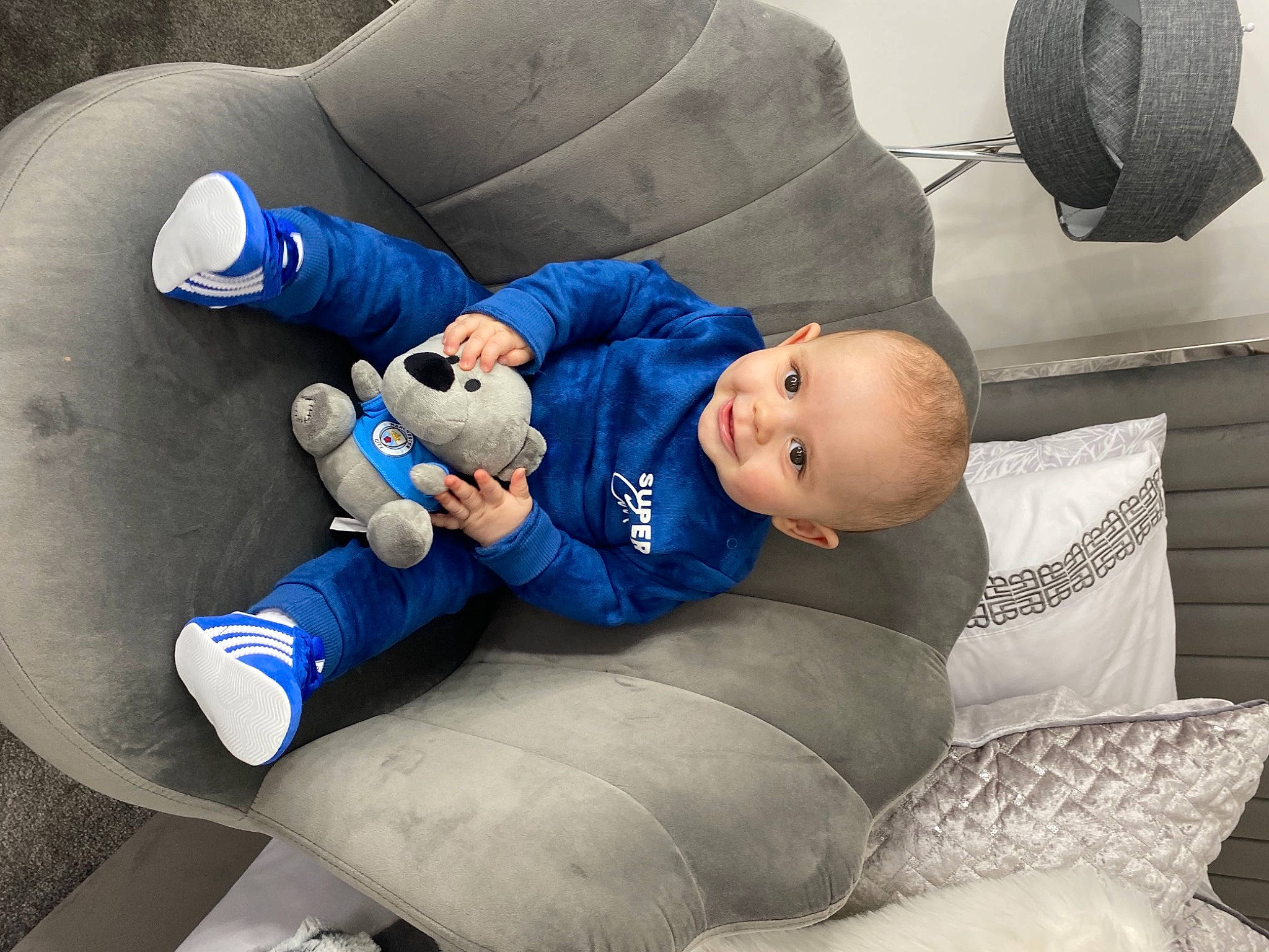 Finnley joined the competition — help win amazing prizes! baby, baby_toddler_clothing, child, comfort, couch, electric_blue, face, fun, grass, hat, human_leg, knee, leg, person, room, sitting, smile, sneakers, sock, toddler