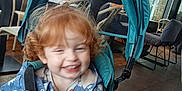 Fréya a rejoint le concours — aidez-le/la à gagner de superbes lots ! blue, blur, cafe, chair, child, curly_hair, floor, floral, hands, happy, indoor, jacket, person, red_hair, seat, smiling, stroller, table, toddler, window